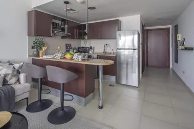 a kitchen with a counter and a refrigerator at Frank Porter - Dubai Arch Tower , JLT in Dubai