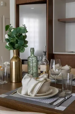 a dining room table with a plate and a vase of flowers at Frank Porter - Palace Beach Residence Tower 1 in Dubai