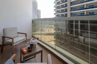 a room with a balcony with a chair and a table at Frank Porter - Hera Tower in Dubai