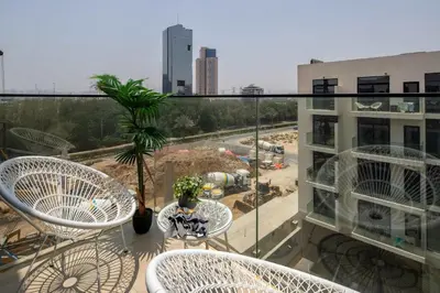 a balcony with three chairs and a table on a building at Frank Porter - Elysee III by Pantheon, JVC in Dubai