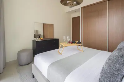 a bedroom with a bed and a table with glasses on it at Frank Porter - Palace Beach Residence Tower 2 in Dubai