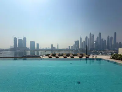 a swimming pool with a city skyline in the background at Frank Porter - Palace Beach Residence Tower 2 in Dubai