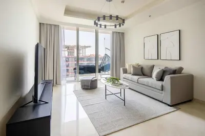 a living room with a couch and a tv at Frank Porter - Palace Beach Residence Tower 2 in Dubai