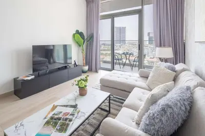 a living room with a couch and a tv at Frank Porter - Bloom Heights Tower B in Dubai