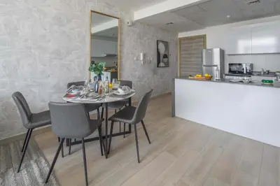 a dining room with a table and chairs and a kitchen at Frank Porter - Bloom Heights Tower B in Dubai