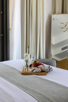 a tray with wine glasses and flowers on a bed at Frank Porter - Aykon City Tower C in Dubai
