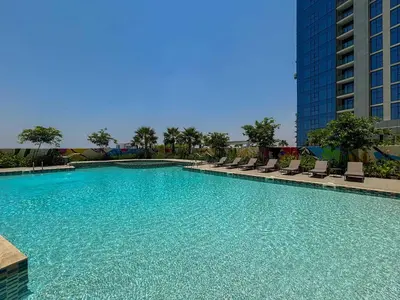 a large swimming pool with chairs and a building at Frank Porter - Aykon City Tower C in Dubai
