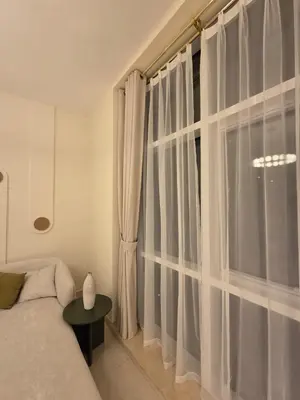 a bedroom with a large window with white curtains at Duja Tower in Dubai