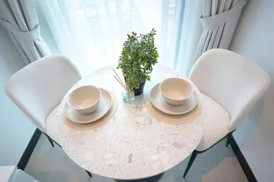 a white table with two hats and a plant on it at Cozy Studio, All Bills Included in Dubai