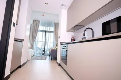 a kitchen with white walls and a large window at Cozy Studio, All Bills Included in Dubai