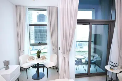 a living room with a table and chairs and a window at Cozy Studio, All Bills Included in Dubai