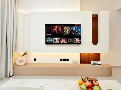 a living room with a flat screen tv on a wall at Elegant 2BR Apartment in Socio Tower - Dubai Hills in Dubai