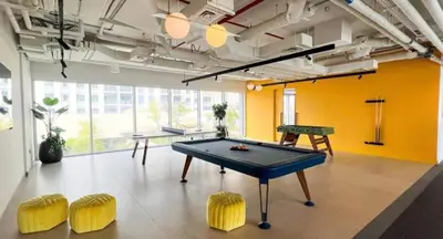 a room with a ping pong table and yellow chairs at Elegant 2BR Apartment in Socio Tower - Dubai Hills in Dubai