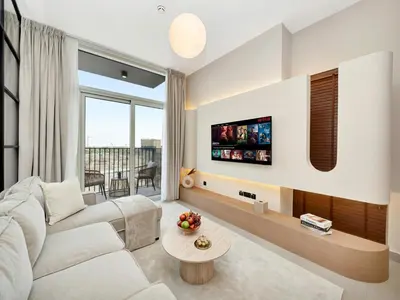a living room with a white couch and a tv at Elegant 2BR Apartment in Socio Tower - Dubai Hills in Dubai
