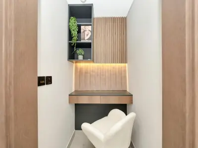a white chair sitting in front of a fireplace at Elegant 2BR Apartment in Socio Tower - Dubai Hills in Dubai