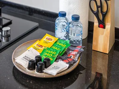 a plate with food and bottles of water and scissors at Livin' Holidays - 1 BR - Next to Miracle garden in Dubai