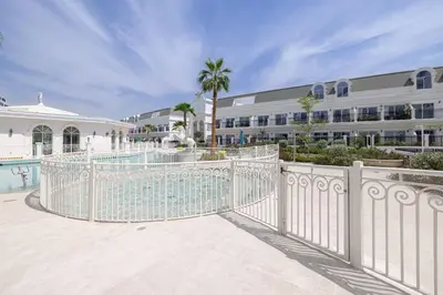 a white gate in front of a building at Livin' Holidays - 1 BR - Next to Miracle garden in Dubai