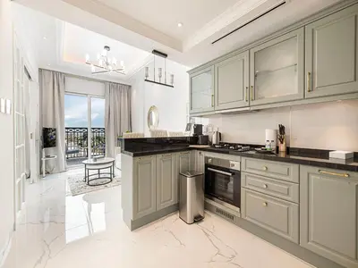 a kitchen with gray cabinets and a large window at Livin' Holidays - 1 BR - Next to Miracle garden in Dubai