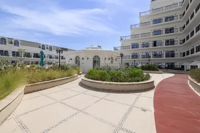 a courtyard in front of a building with two buildings at Livin' Holidays - 1 BR - Next to Miracle garden in Dubai