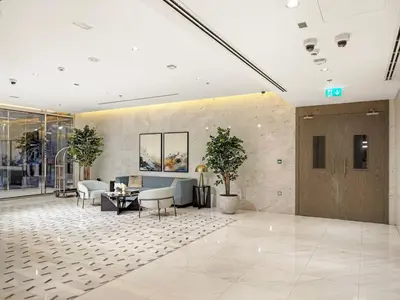 a lobby with a couch and a table and chairs at Spacious 1BR for 2, 10 Min Meydan Racecourse, Pool & Gym Access in Dubai