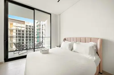 a bedroom with a white bed and a large window at FIRST CLASS Studio Cozy Luxury Escape in Dubai