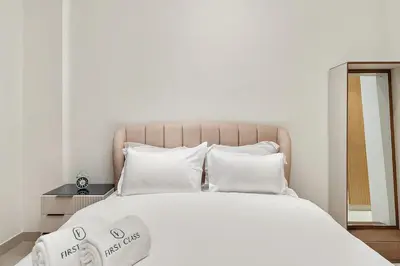 a bedroom with a large bed with white sheets and pillows at FIRST CLASS Studio Cozy Luxury Escape in Dubai
