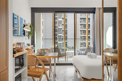 a kitchen and living room with a table and a dining room at FIRST CLASS Studio Luxury Comfort , Pool View in Dubai