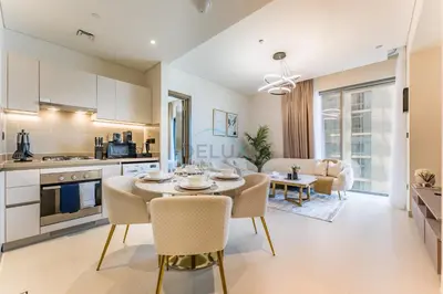 a kitchen and living room with a table and chairs at Modern Apartment Near Sobha Hartland Amenities, Minutes from Ras Al Khor Wildlife Sanctuary and Downtown Dubai, Sobha Creek Vistas Tower A, Sobha Hartland by Deluxe Holiday Homes in Dubai