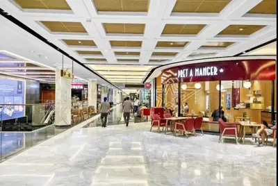 a shopping mall with tables and chairs and people walking in it at Index Tower DIFC with Burj Khalifa View Chic 1 BR in Dubai
