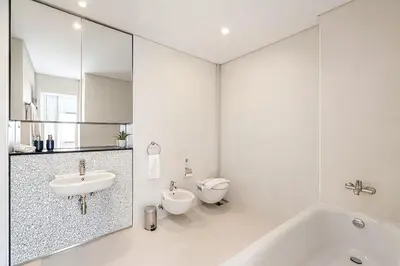 a bathroom with a tub and a sink and a toilet at Index Tower DIFC with Burj Khalifa View Chic 1 BR in Dubai