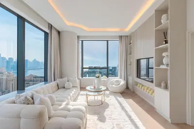 a living room with white furniture and large windows at Daniels 1BR with Sea View at The Palm Tower in Dubai