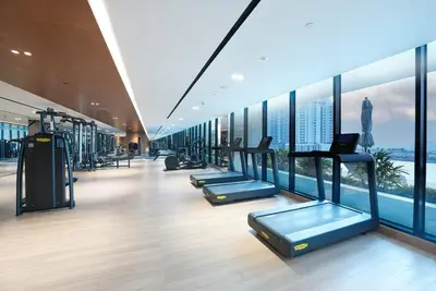 a gym with a row of treadmills and windows at Luxury Trillionaire Studio with Jacuzzi and Canal Views in Business Bay in Dubai