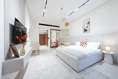 a white bedroom with a large white bed and white walls at Luxury Trillionaire Studio with Jacuzzi and Canal Views in Business Bay in Dubai