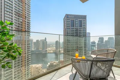 a balcony with a table and two drinks on it at VayK - Elegant Canal View studio in Business Bay in Dubai