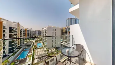 a balcony with a table and a view of a city at Locations l Luxurious Studio l Free Pool, Gym Access l Meydan in Dubai