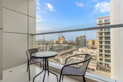 a table and two chairs on a balcony with a view at Charming 1BR with Balcony and City View in JVC in Dubai