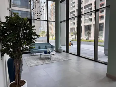 a living room with a couch and a table and windows at Elegant Studio in Peninsula One, Business Bay in Dubai