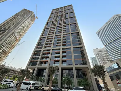 a tall building with palm trees in a city at Elegant Studio in Peninsula One, Business Bay in Dubai