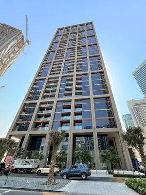 a tall building with cars parked in a parking lot at Elegant Studio in Peninsula One, Business Bay in Dubai