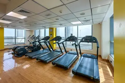 a row of treadmills in a gym with a row at Modern 1-Bedroom Apartment in Bay Central Tower 1 in Dubai