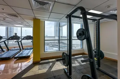 a gym with several tread machines and a large window at Modern 1-Bedroom Apartment in Bay Central Tower 1 in Dubai