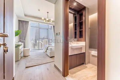 a bathroom with a sink and a bed and a window at Breathtaking Burj Khalifa Views from a High-Floor 3BR with an Assistant Room, Just Minutes from Dubai Mall and Downtown Attractions, Imperial Avenue, Downtown Dubai by Deluxe Holiday Homes in Dubai