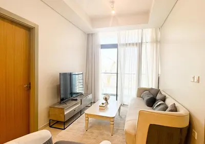 a living room with a couch and a tv at Dream Shoma- Experience Luxury Living 2BR APT in Dubai