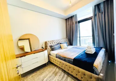 a bedroom with a bed with a mirror and a window at Dream Shoma- Experience Luxury Living 2BR APT in Dubai