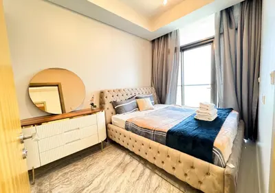 a bedroom with a bed and a mirror and a window at Dream Shoma- Experience Luxury Living 2BR APT in Dubai