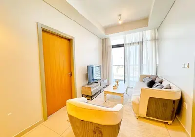a living room with a couch and a television at Dream Shoma- Experience Luxury Living 2BR APT in Dubai