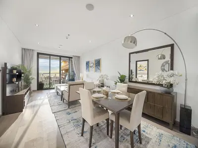 a dining room and living room with a table and chairs at Livin' Holidays - 1 BR - Anantara Lagoon Stay in Dubai
