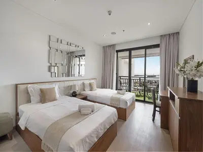 a hotel room with two beds and a balcony at Livin' Holidays - 2 BR - Anantara Palm Stay in Dubai