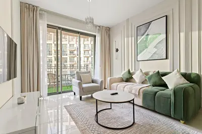 a living room with a green couch and a table at FIRST CLASS 1BR Burj Khalifa View , Near Metro in Dubai
