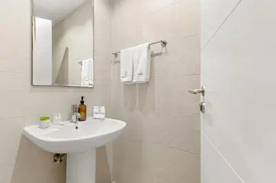 a white bathroom with a sink and a mirror at FIRST CLASS 1BR Burj Khalifa View , Near Metro in Dubai